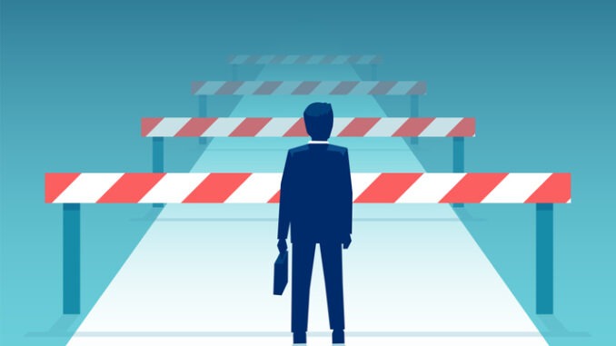 Vector of a challenged businessman standing in front of many obstacles and barriers on the way to success.