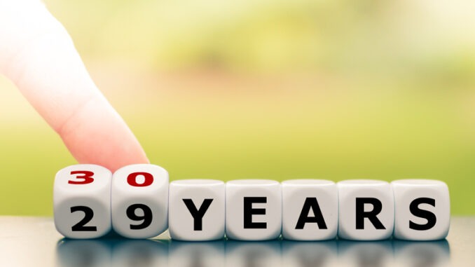 Hand turns dice and changes the expression "29 years" to "30 years".