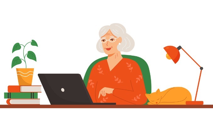 Happy older lady working on a laptop at home