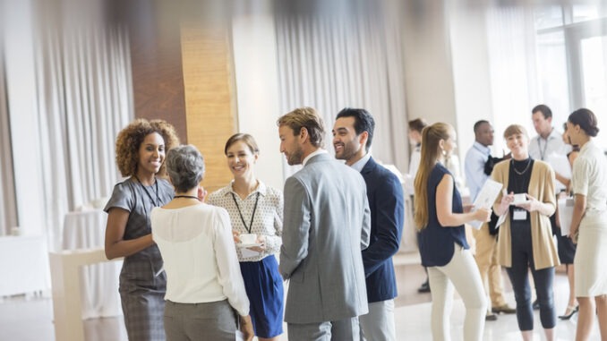 Group of business people standing in hall, smiling and talking together