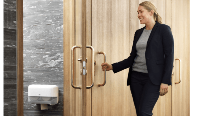 smiling employee opening bathroom door