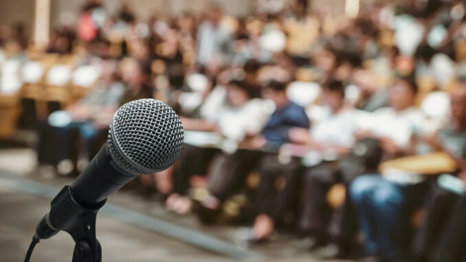 Microphone over the Abstract blurred photo of conference 