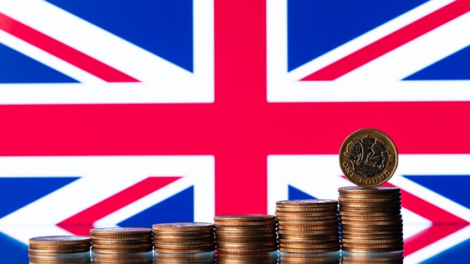 One pound coin against the background of a fragment of the flag of Great Britain