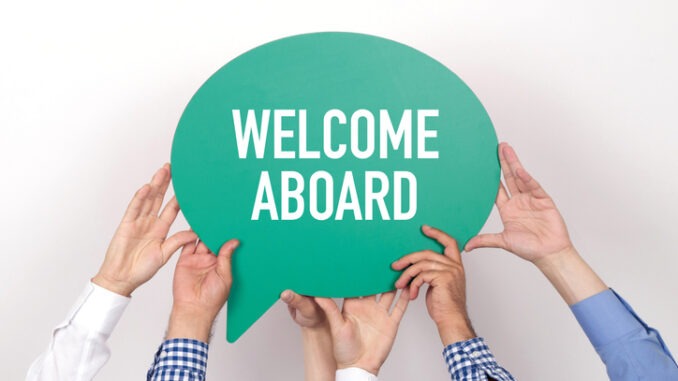 Group of people holding the WELCOME ABOARD written speech bubble