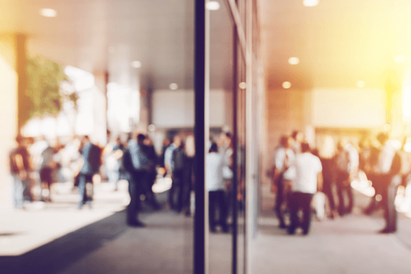 A group of people standing outside a building and a glass wall networking.