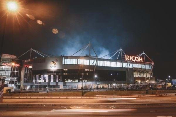 Photo of The Ricoh Arean at night lit up by street lights.