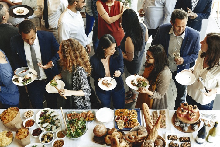 A photo taken from above of a busy buffet and people standing around eating.