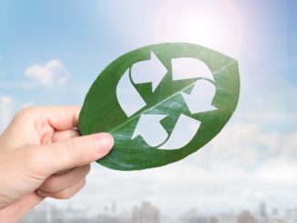 hand-holding-leaf-with-hole-of-recycling-symbol-resource-recovery-picture-id1130708639