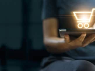 Online shopping and digital marketing concept, Woman using digital tablet with shopping cart icon on screen on dark background.