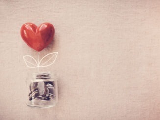 a jar of heart tree growing on money coins, social responsibility and donation concept