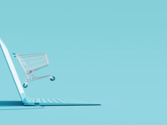 Online shopping concept. Laptop and shopping cart on blue background