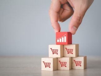 Hand arranging wood block stacking with icon Graph and shopping cart symbol