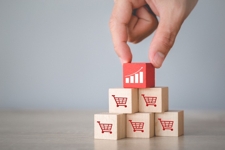 Hand arranging wood block stacking with icon Graph and shopping cart symbol