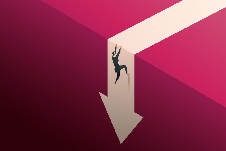 Businessman climbs a cliff to escape from a falling arrow.