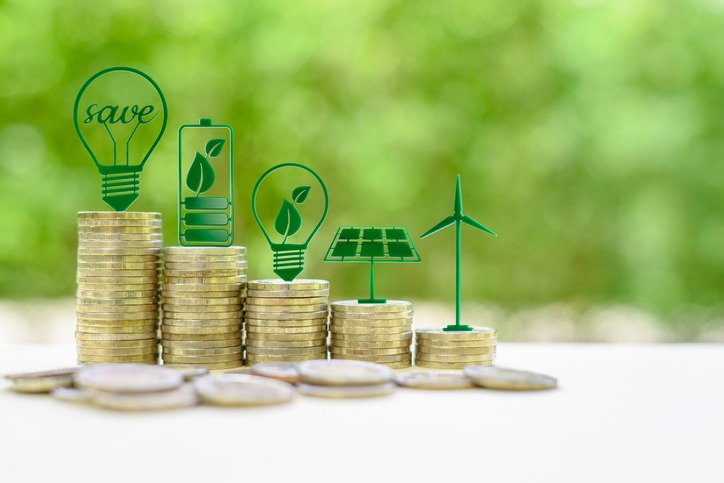 lternative or renewable energy financing program, financial concept : Green eco-friendly or sustainable energy symbols atop five coin stacks e.g a light bulb, a rechargeable battery, solar cell panel