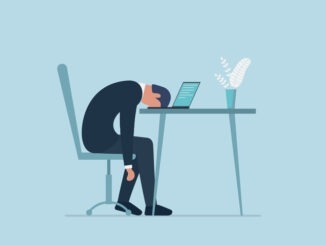 Professional burnout syndrome. Exhausted sick tired male manager in office sad boring sitting with head down on laptop.