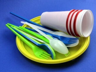 Disposable tableware in a pile lie on a blue background
