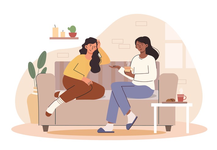 Women drinking coffee sit on couch spending time together and chatting