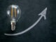 Crisis of energy production. Rising electricity prices.Light bulb and up arrowon on a black chalk board.Electricity cost.Saving electricity concept