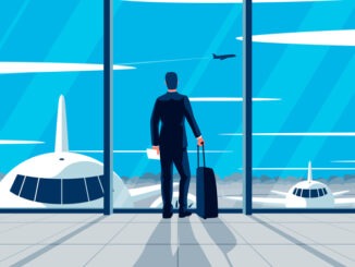 businessman standing in the airport. Concept of a man wearing suit with suitcase standing in the airport lounge looking at the airfield. Departure awaiting hall interior