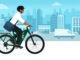 Business man riding an eco-friendly electric bike in the city street, sustainable mobility concept