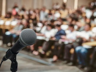 Microphone over the Abstract blurred photo of conference