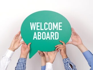 Group of people holding the WELCOME ABOARD written speech bubble