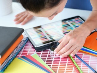 Woman designer looks through magnifying glass at color palette