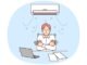 Man sitting at office desk under air conditioner freezes due to cold temperatures