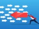 Businessman pushing arrow in opposite direction